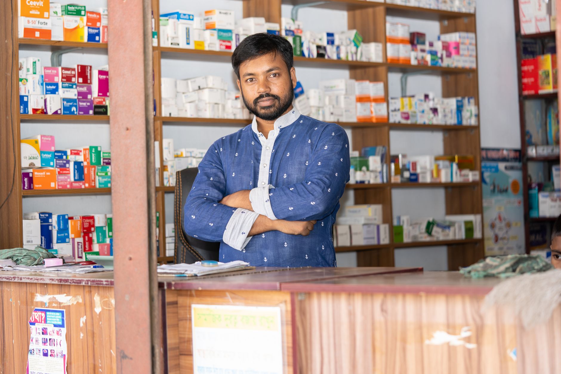 Pharmacist standing behind the counter of his store