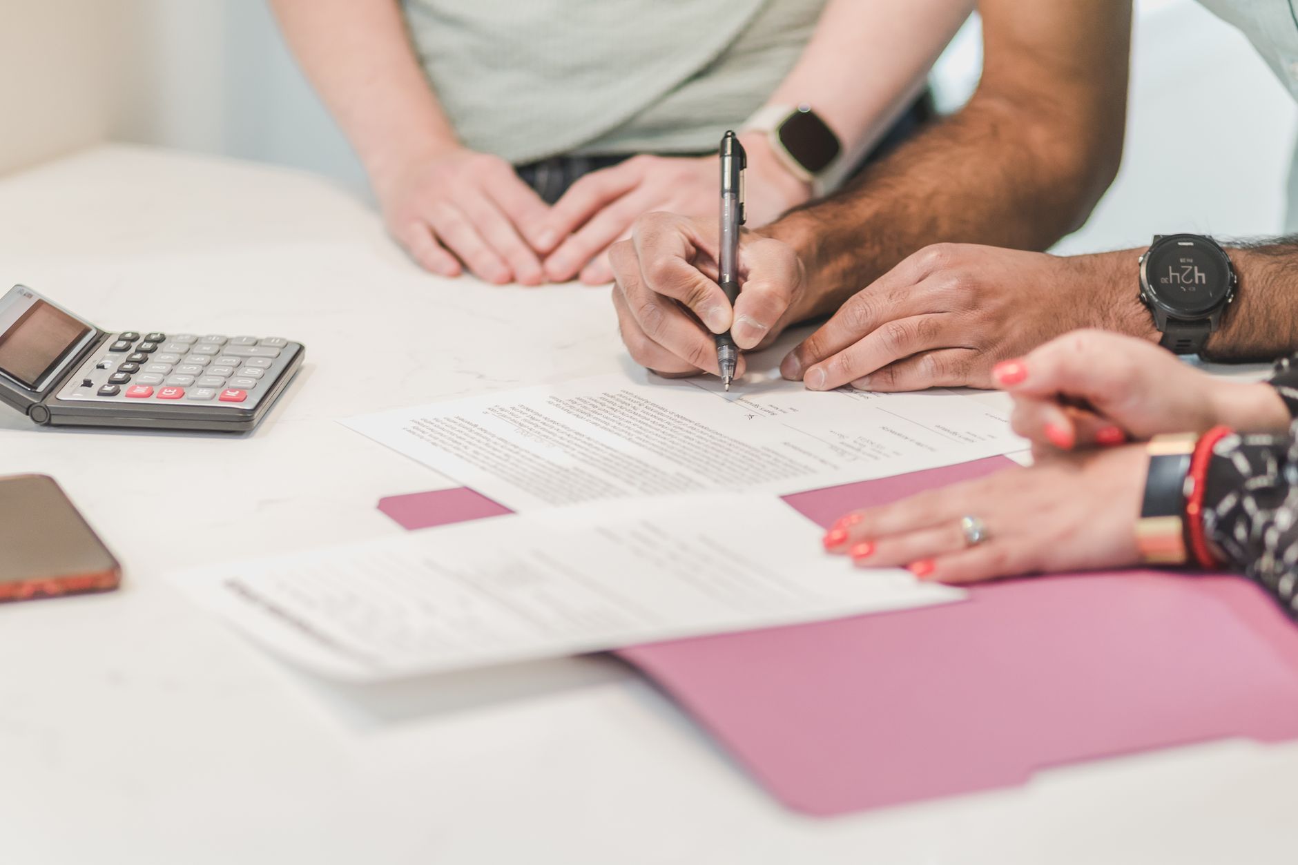 Business owner reviewing loan and collateral documents with a calculator