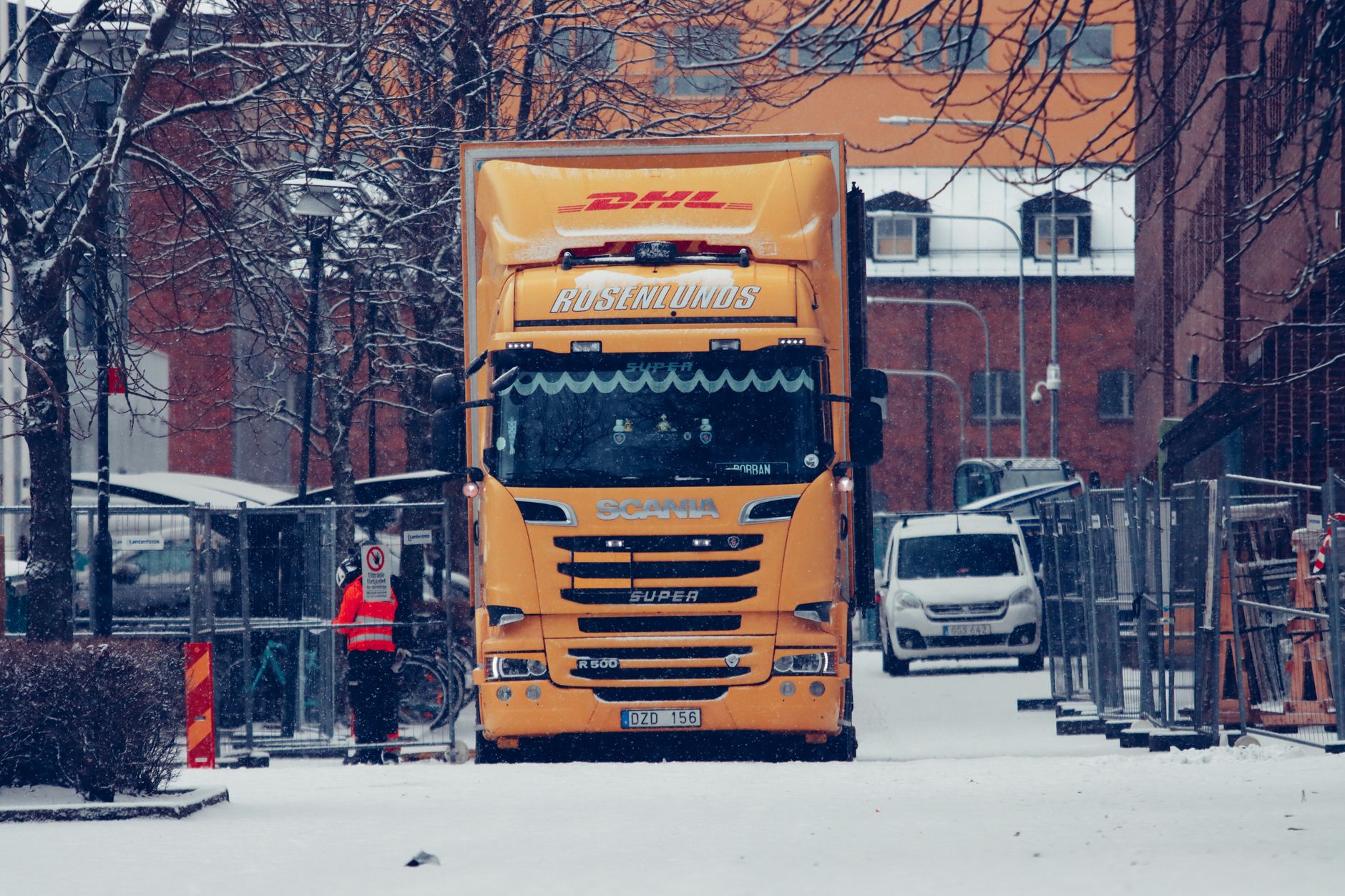 Snowplow truck on a snowy street representing a seasonal landscaping and snow removal business