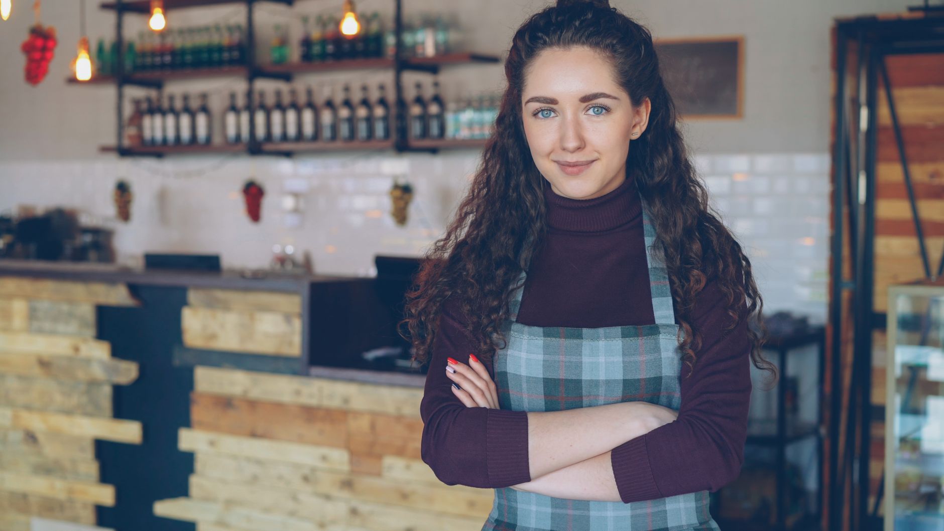 Confident small business owner in a cafe representing a low-risk, steady-revenue Revenue Based Funding applicant