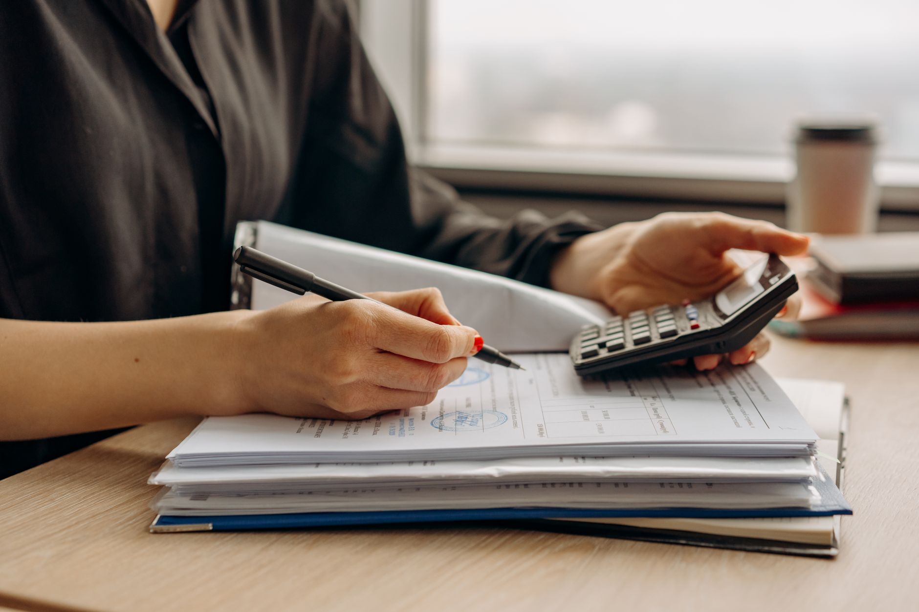 Person using a calculator with financial documents